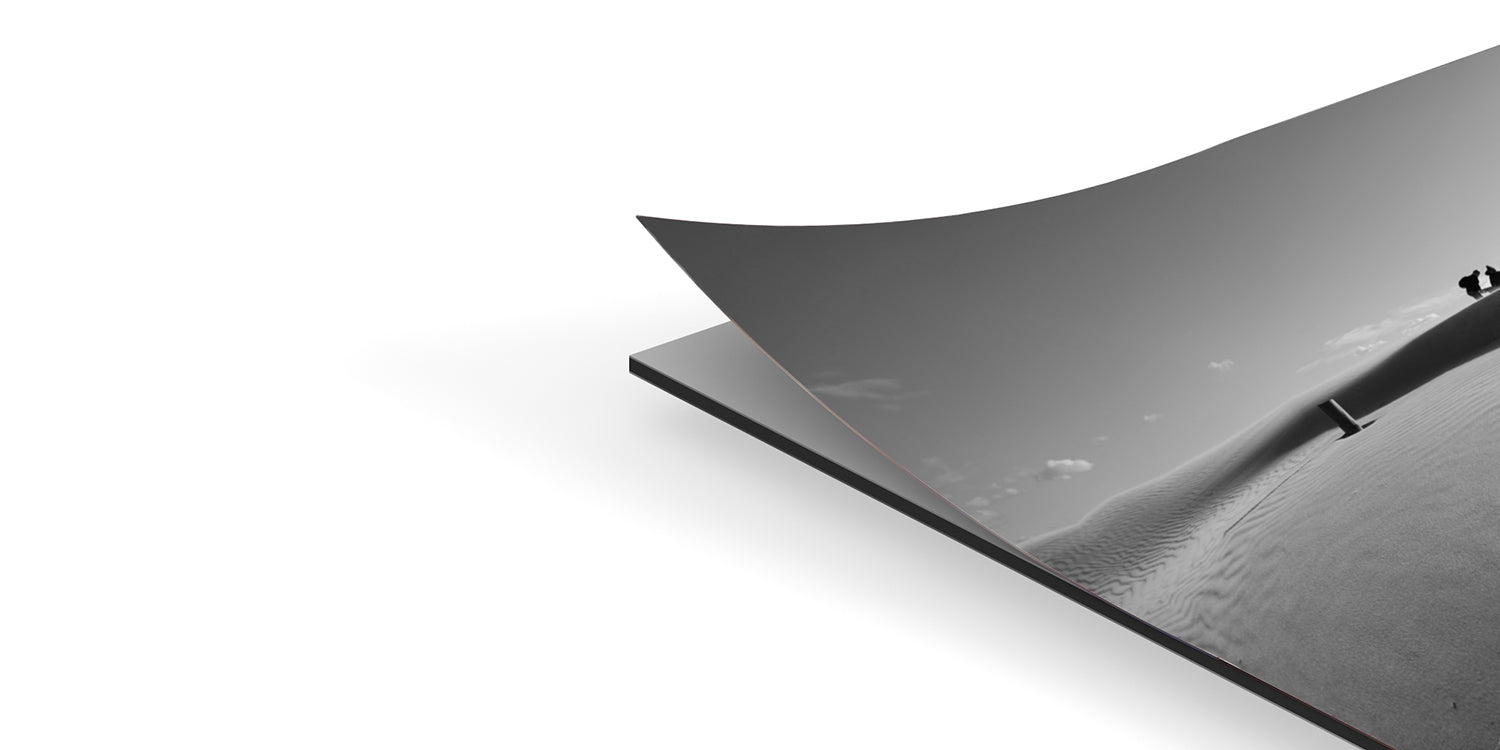 Dibond backing support detail - black and white photo corner lifted showing mounting process on aluminum composite